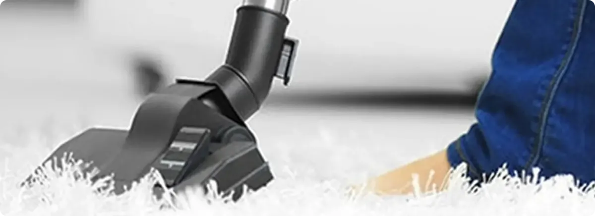 Close-up of a professional vacuuming a white carpet in Hampton.